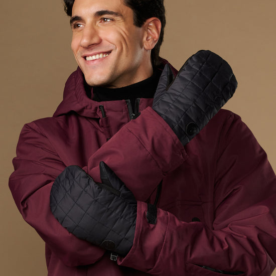 Pair of black quilted mittens shown from the back and side.