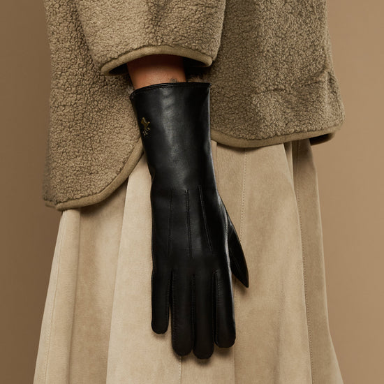 Black leather gloves with long silhouette and pointed fur-lined wrist