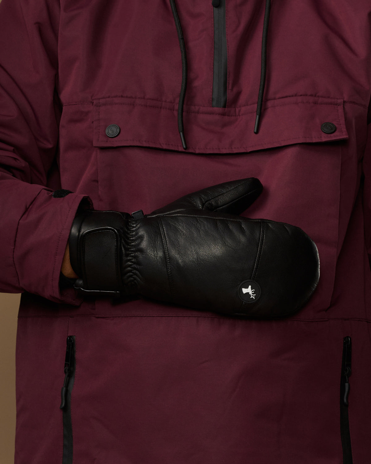 Black leather mitten with a gathered wrist cuff and small logo patch.