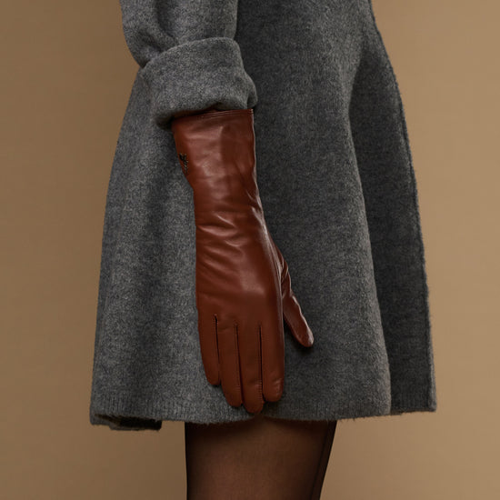 Extra-long cognac leather glove side view, smooth cuff with seam lines