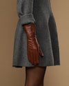 Extra-long cognac leather glove side view, smooth cuff with seam lines