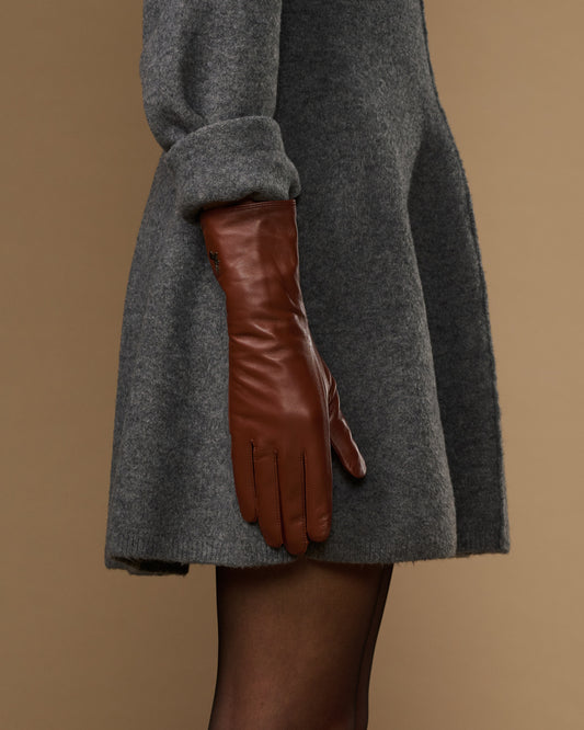 Extra-long cognac leather glove side view, smooth cuff with seam lines
