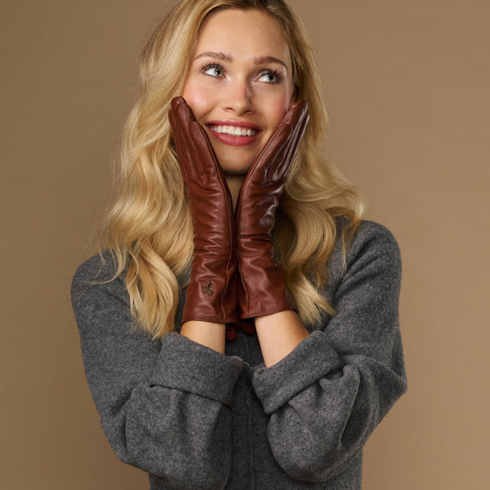 Extra-long cognac leather gloves with plush cuff and small crest at the wrist