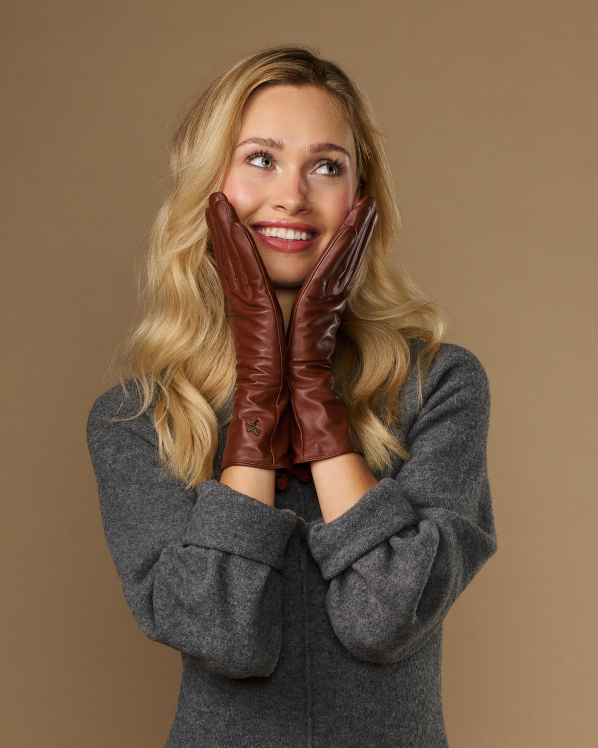 Extra-long cognac leather gloves with plush cuff and small crest at the wrist