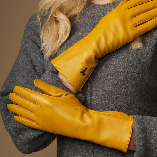 Yellow extra-long leather gloves; cashmere-lined cuffs and stitched logo on the wrist