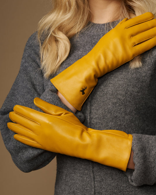 Yellow extra-long leather gloves; cashmere-lined cuffs and stitched logo on the wrist