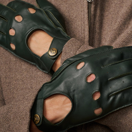 Dark green lambskin driving gloves close-up with perforated finger panels and button
