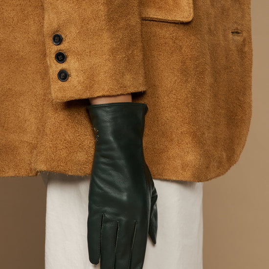 Close-up of dark green leather glove with stitched palm and tapered fingers