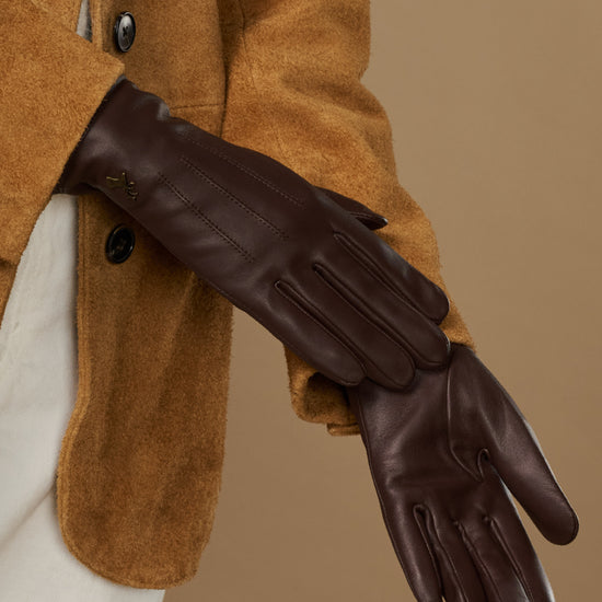 Brown leather gloves with fleece lining, close-up side view of one glove