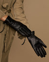 Black leather gloves with side zipper and wrist ties, angled close-up