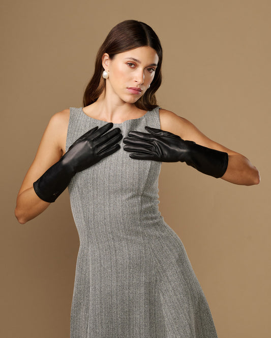 Women’s mid-forearm black leather gloves with smooth finish and snug fit