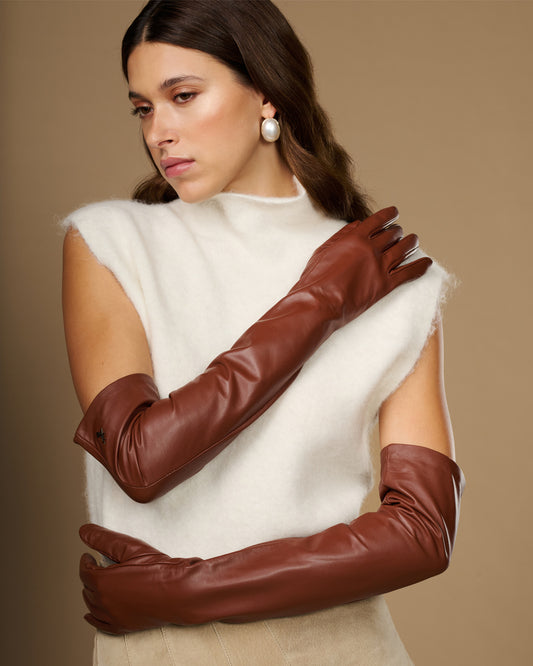Chestnut brown leather opera gloves in a crossed-arm pose, long sleeves and cuffs