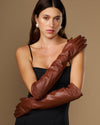 Chocolate brown leather elbow gloves worn close-up showing wrinkle-free texture