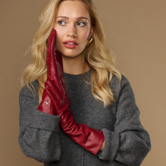 Red leather mid-forearm gloves with tailored seams and smooth wrist opening