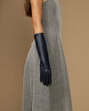 Women’s below-elbow dark blue leather glove on arm, smooth lambskin and snug cuff