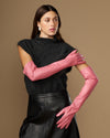 Women's pink leather gloves, one arm raised, long fitted cuff