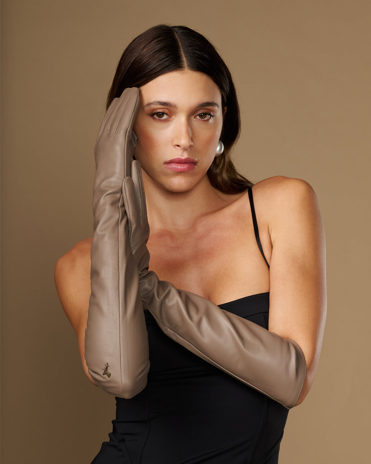 Taupe lambskin elbow-length leather glove close-up near face