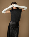 Women's white leather gloves with long cuffs, raised hands covering forehead
