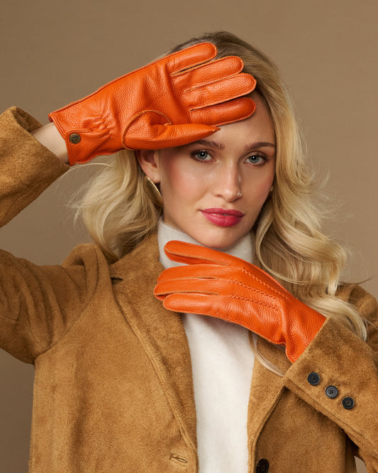 Orange leather deerskin gloves with stitched fingers and soft cuff lining, worn on hands