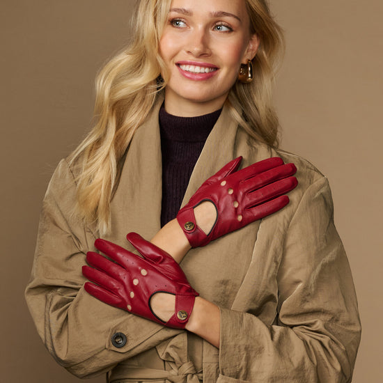 Women’s red leather driving gloves with cutout knuckles and buttoned wrist straps