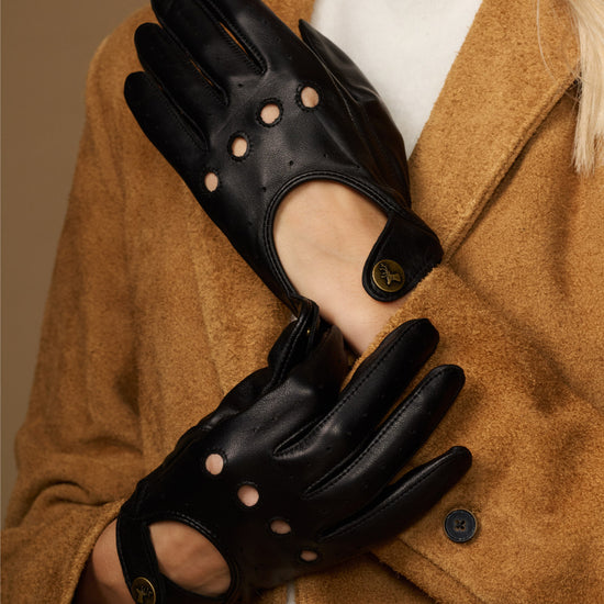 Pair of black leather driving gloves with studded accents and touchscreen fingertips.