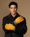 Yellow leather gloves with gray fleece cuffs, hands crossed in front